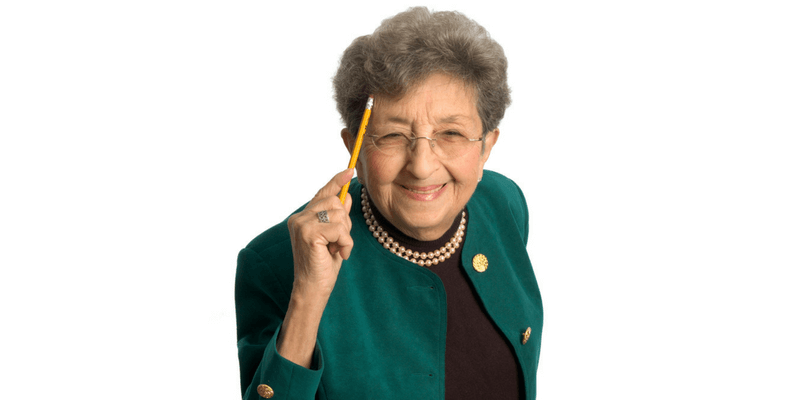Elderly woman holding a pencil to her head: wondering if she should get vein treatment.