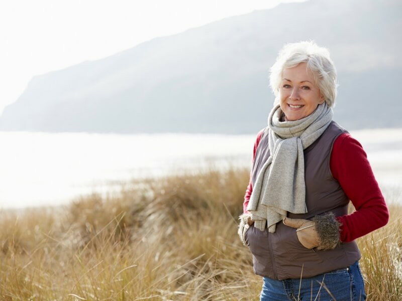 A woman in scarf and vest on a walk, living a life after getting Endovenous Laser Therapy (EVLT) treatment.