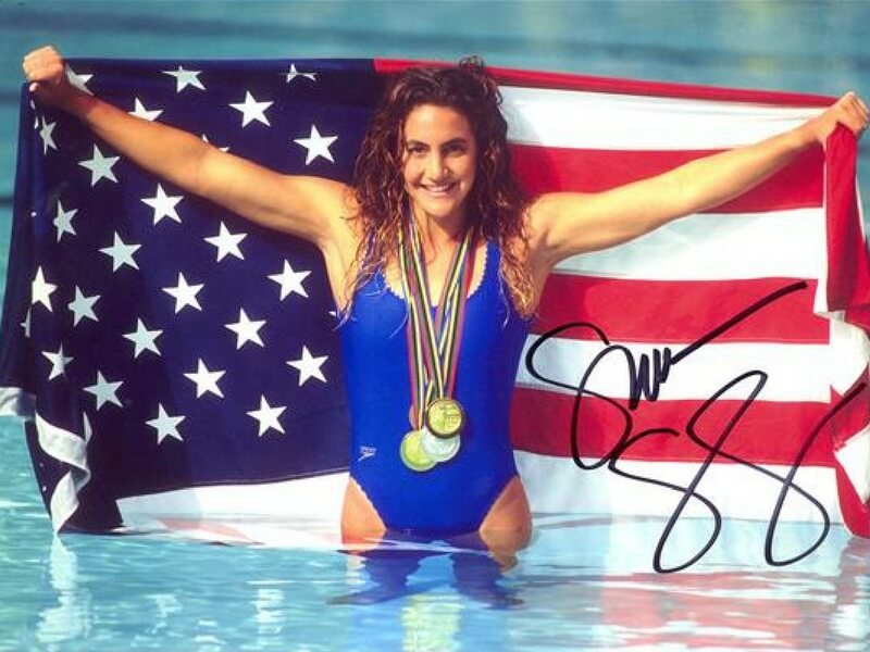 An Olympic swimmer, who has varicose veins, with medals and the American flag--in a pool.