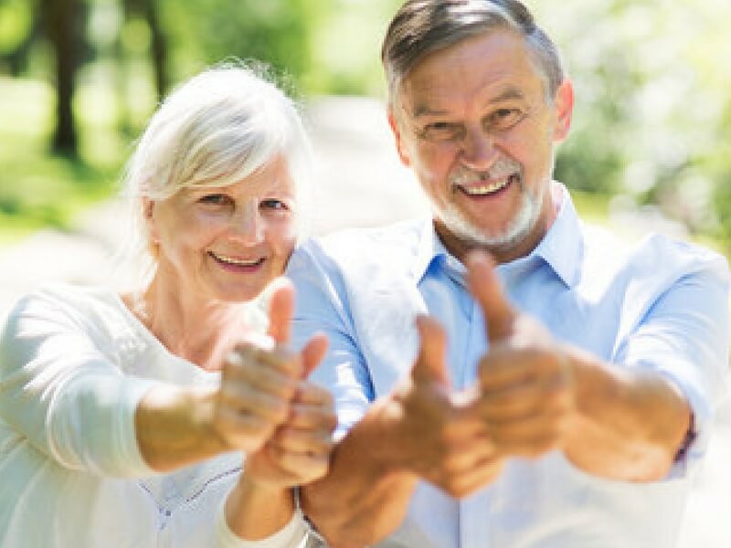 A smiling couple both with thumbs up because Endovenous Laser Therapy (EVLT) changed their lives.