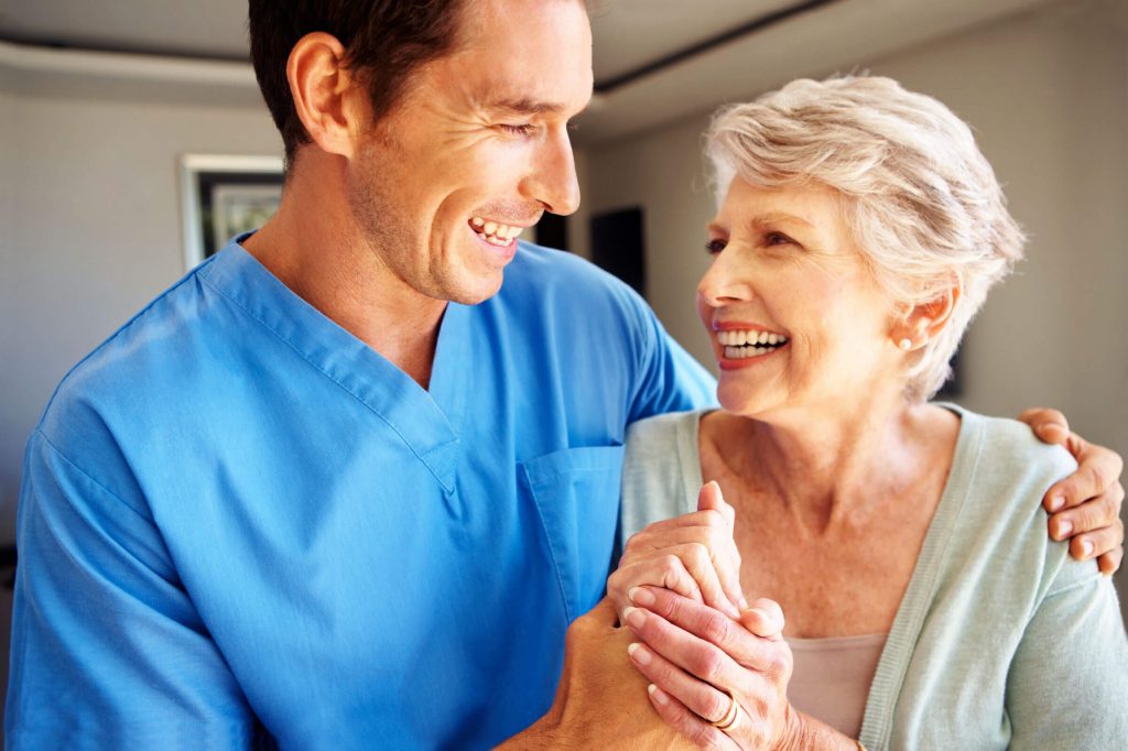 Male doctor hugging an elderly patient after she got non-invasive vein treatment.