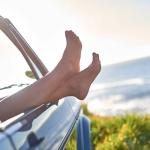 woman hanging legs outside car