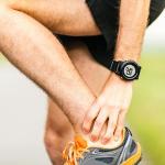 Man massaging sore calf and Achilles tendon during workout