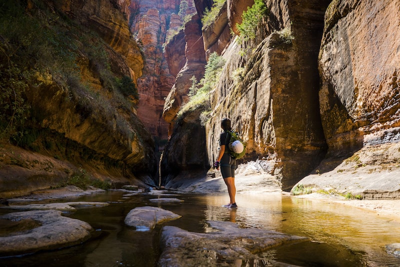 woman standing in a creek during an outdoor hike