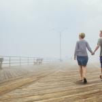 couple holding hands taking a walk on a pier