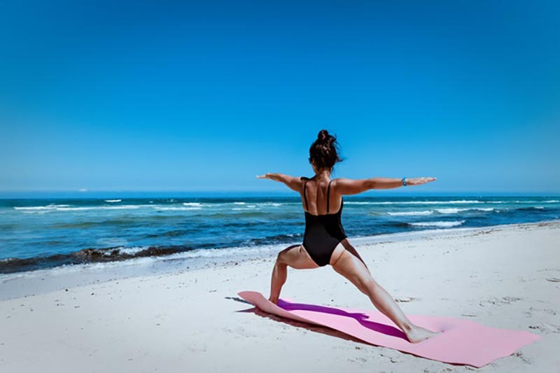Woman doing yoga pose on the beach