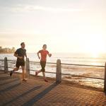 fit couple running on a pier