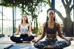 Multi-ethnic females are meditating in yoga class