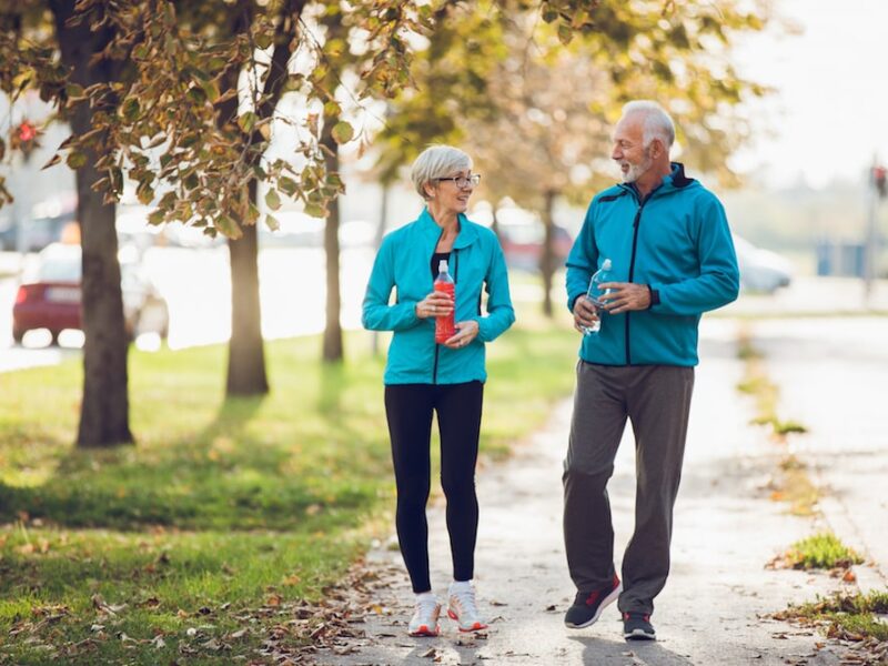 Mature couple walking together with water bottles