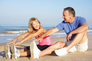 Happy couple stretching their legs on the beach