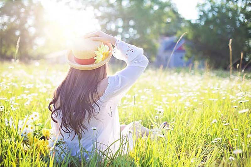 woman sitting in a field of white flowers