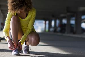 Woman tying a shoelace before workout